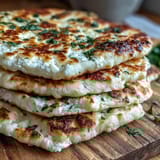 Warm, bubbling Fluffy Cottage Cheese Flatbread topped with fresh herbs, ready for a quick lunch.