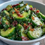 Crispy smashed cucumbers tossed in tangy garlic chili oil dressing, garnished with sesame seeds and scallions.