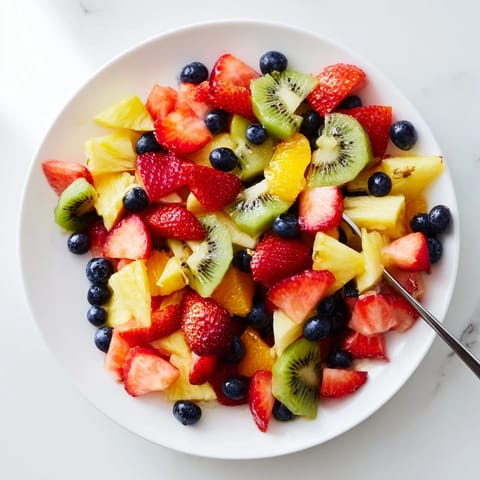 Colorful Fruit Salad, a medley of grapes and blueberries, served fresh with a garnish of mint.