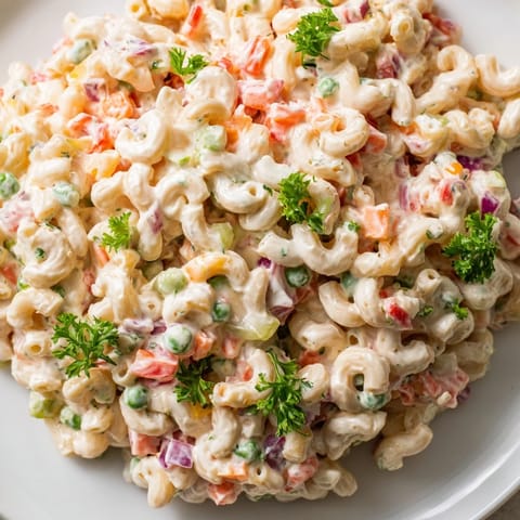 Fork-full of bright, tangy Macaroni Salad featuring crunchy celery, bell pepper, and tender pasta.