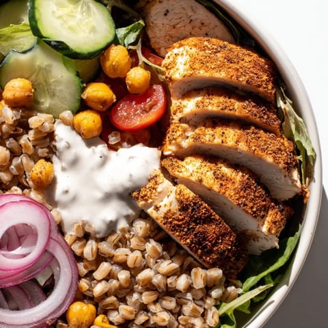 Lemon Tahini Chicken Power Bowl served warm, featuring golden roasted chicken, fluffy farro, crisp veggies, and a creamy, zesty lemon-tahini sauce.