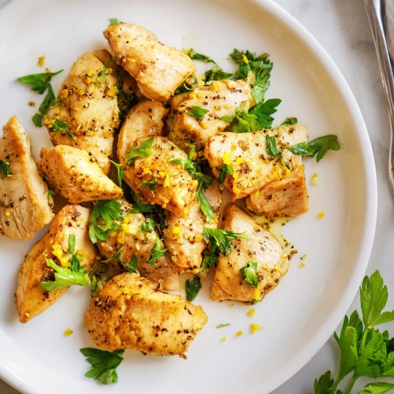Sizzling pan-seared Lemon Pepper Chicken in a cast-iron skillet with steam rising and a crisp, golden crust.