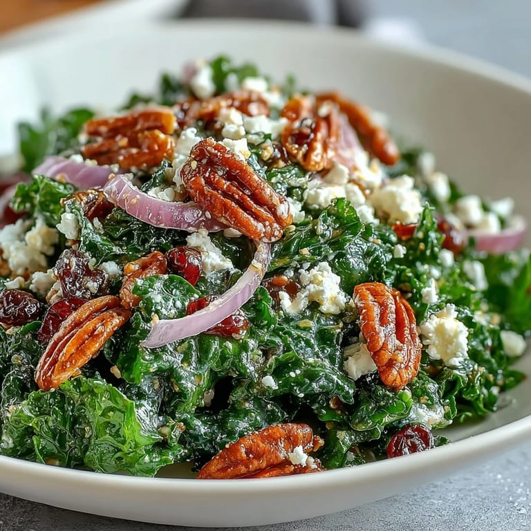 Vibrant massaged kale tossed in warm maple-mustard glaze, topped with crunchy pecans and sweet cranberries for a comforting salad.